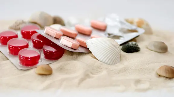 Tabletten und Muscheln am Strand