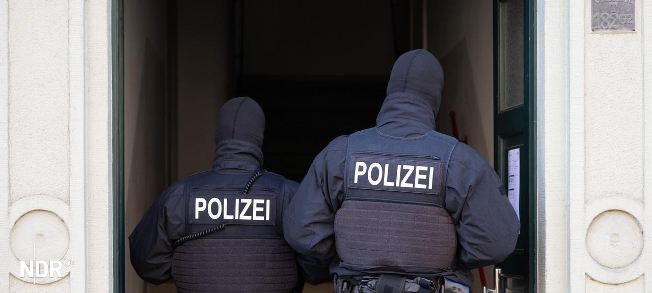 Polizisten stehen während einer Razzia in einer Haustür. (Symbolbild) | picture alliance/dpa , Sebastian Kahnert Polizisten stehen während einer Razzia in einer Haustür. (Symbolbild)