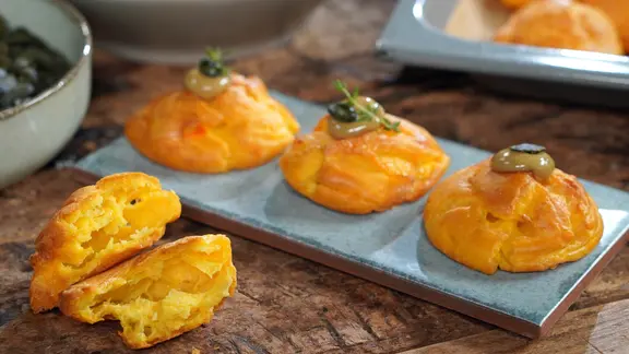 Gougères mit Kürbiskernöl-Mayonnaise auf einer Platte serviert