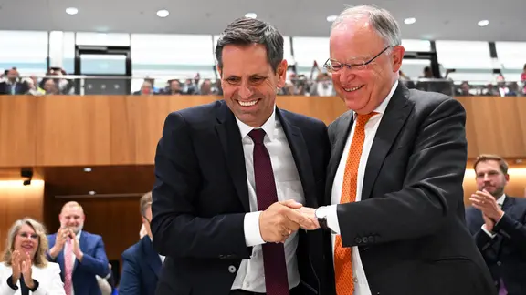 Olaf Lies (SPD, l) wird nach seiner Wahl zum Ministerpräsidenten von Niedersachsen von Stephan Weil (SPD), scheidender Ministerpräsident von Niedersachsen, während der Sitzung des Niedersächsischen Landtags beglückwünscht.