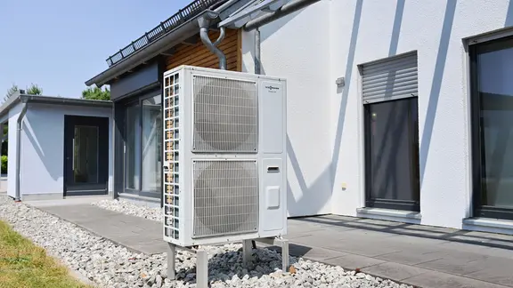 Eine Wärmepumpe vor einem Einfamilienhaus.