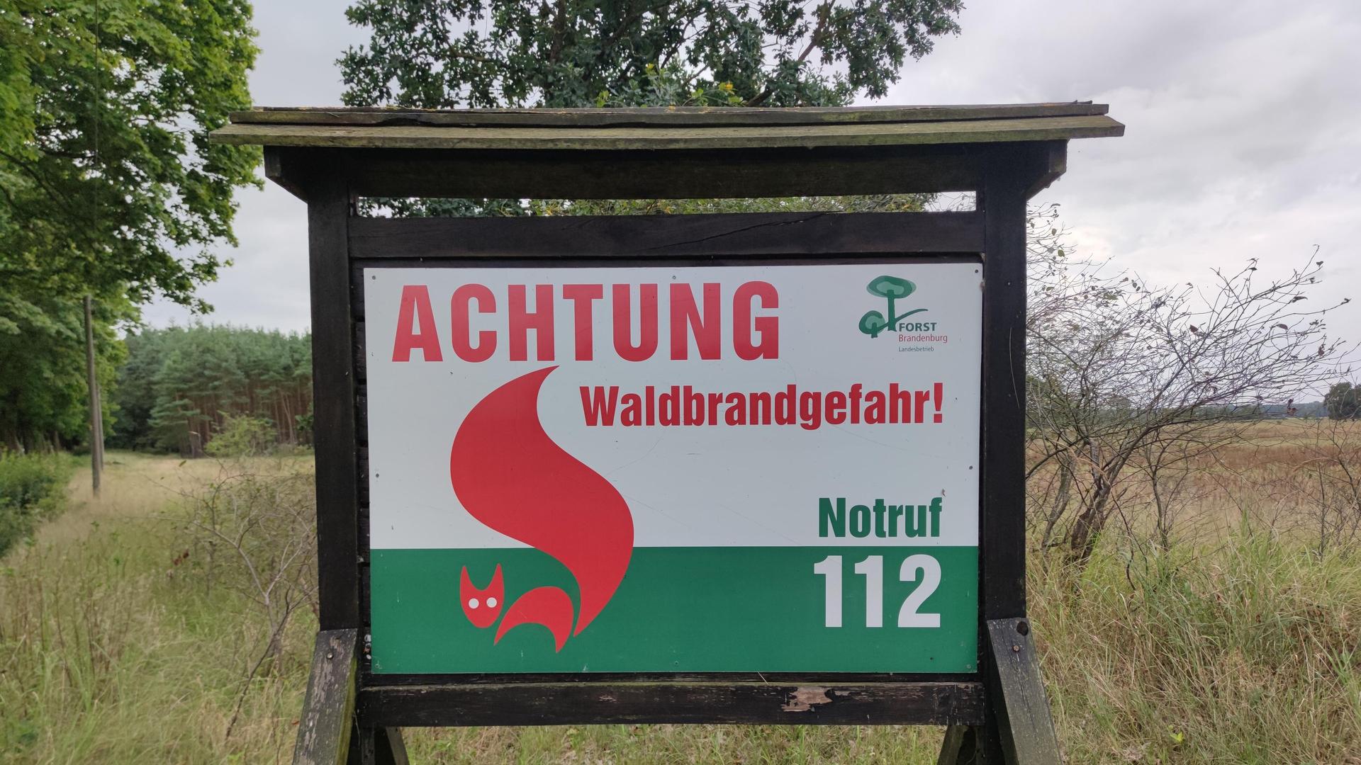 Ein Schild steht vor einem Wald. Auf diesem Schild steht: Achtung, Wald·brand·gefahr. | picture alliance / dts-Agentur