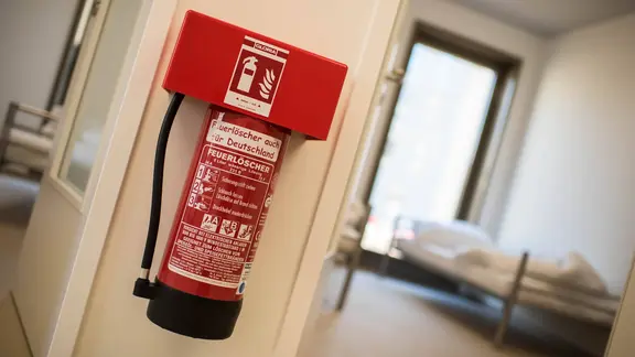 Ein Feuerlöscher hängt auf einem Flur zwischen zwei Schlafräumen.