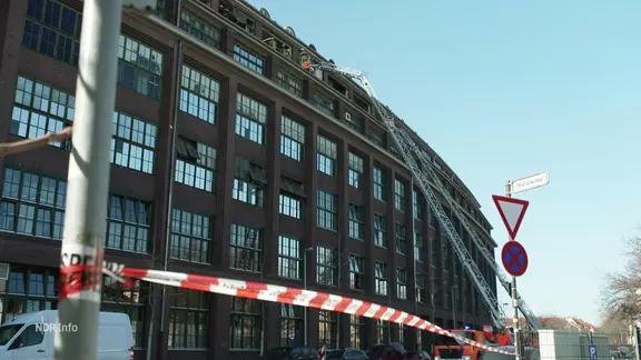Die abgesperrte Fassade des Continentalwerks. Feuerwehleitern führen zur zerstörten Fensterfront des obersten Stockwerkes.
