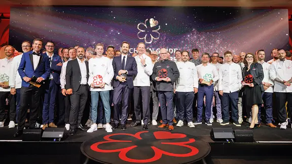 Die Preisträger der Verleihung der Guide-Michelin-Sterne 2025 für deutsche Reastaurants stehen bei einem Gruppenbild zusammen.