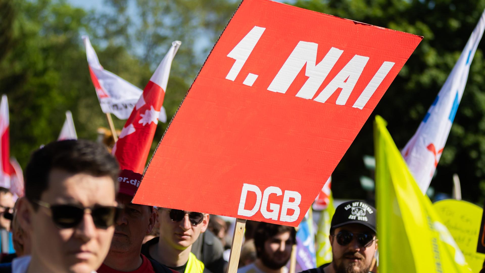 Demonstrierende halten ein selbst gebasteltes Schild mit der Aufschrift 