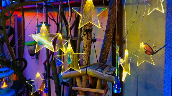 Beleuchtete Sterne an einem Stand auf einem Weihnachtsmarkt.