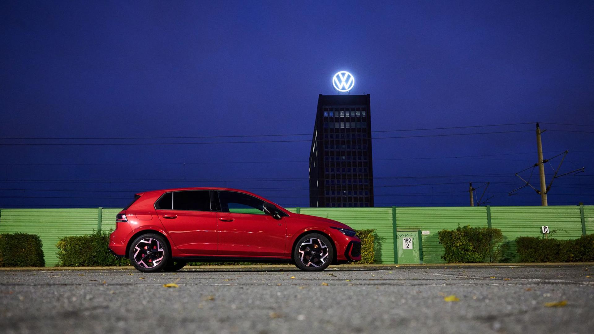 Wolfsburg: Ein roter VW Golf steht auf einem Parkplatz am Volkswagen Stammwerk mit dem Markenhochhaus. | dpa-Bildfunk, Julian Stratenschulte