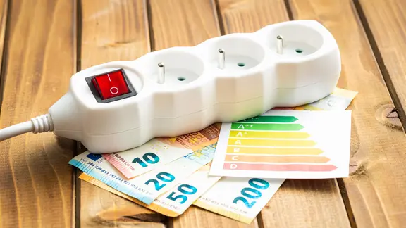 Eine Steckdose liegt auf Euro-Scheinen.