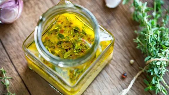 Salatdressing mit Kräutern in einem Glas
