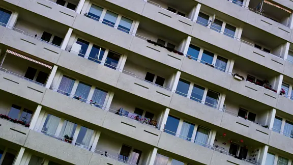 Die Fassade eines Wohnblocks mit vielen Balkonen.
