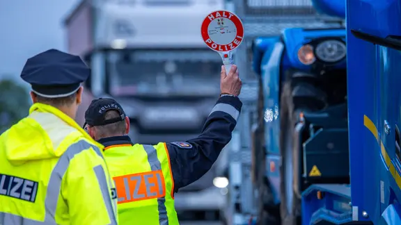 Zwei Polizisten bei einer Verkehrskontrolle. | dpa/Jens Büttner, Jens Büttner Zwei Polizisten bei einer Verkehrskontrolle.