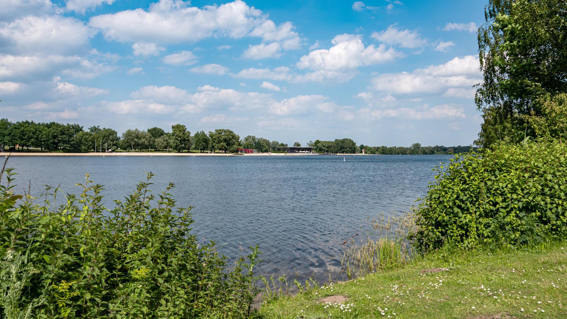 Blick auf einen See eingerahmt von Büschen und Bäumen. | picture alliance