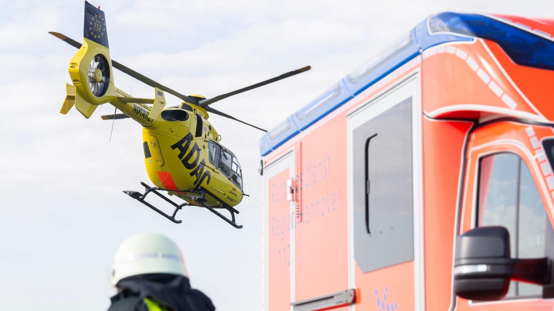 Ein Rettungshubschrauber fliegt über einem Krankenwagen | Julian Stratenschulte/dpa