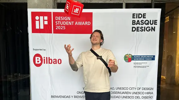 Ein Mann wirft glücklich einen roten Würfel in mit dem Logo des iF-Design Student Award in die Luft.