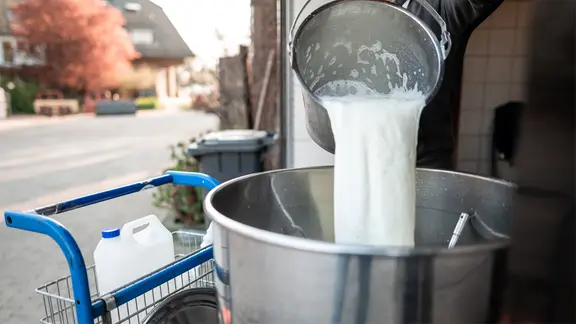 Frische Rohmilch wird in einen großen Bottich gegossen, der zur Befüllung einer Milchtankstelle dient. | picture alliance/dpa | Fabian Strauch, Fabian Strauch Frische Rohmilch wird in einen großen Bottich gegossen, der zur Befüllung einer Milchtankstelle dient.