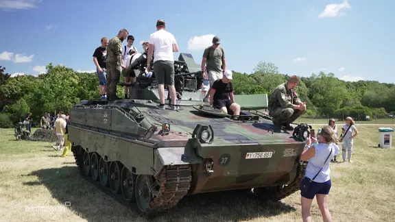 Besucher vom Tag der Bundeswehr begutachten einen Panzer.