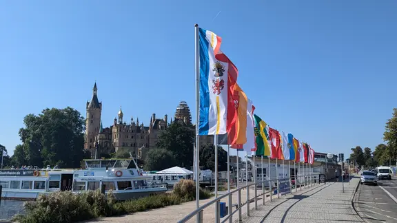 In Sichtweite des Schlosses wehen wenige Tage vor der Einheitsfeier in Schwerin die 16 Flaggen der Bundesländer