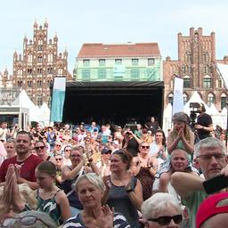 Besucherinnen und Besucher stehen vor der Bühne in Greifswald.