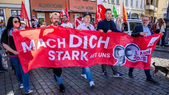 Menschen halten einen Banner mit den Worten "Mach dich stark für uns" hoch