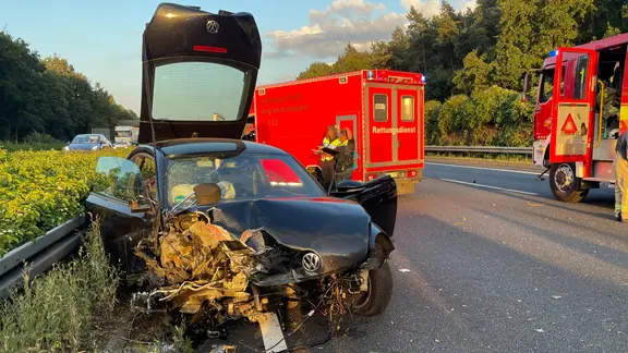 Ein Auto steht auf der A2 an der Leitplanke, der Motorraum des Wagens ist zerstört.
