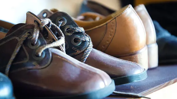 Mehrere Paar Schuhe stehen in einer Reihe.