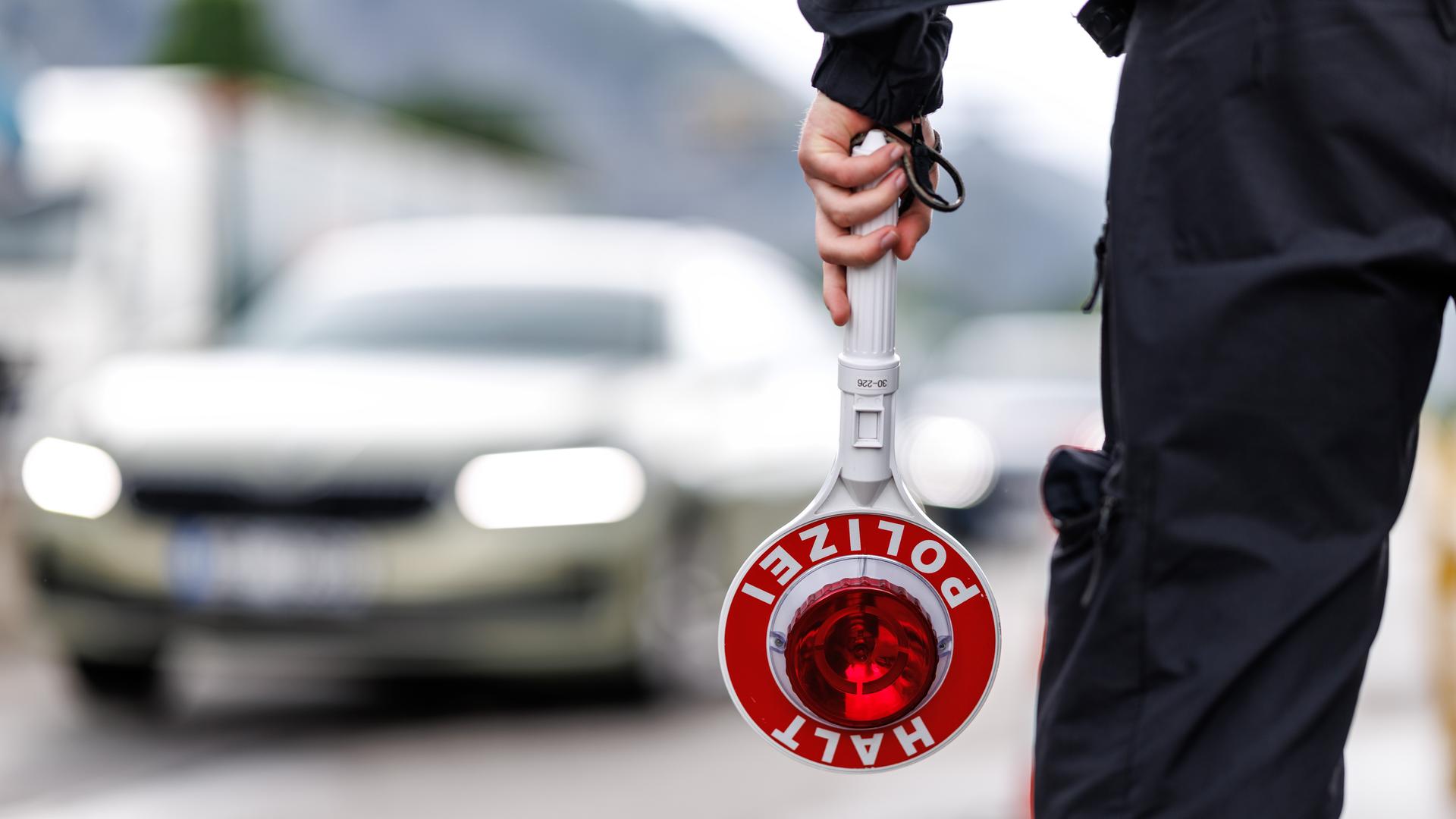 Ein Polizist steht an einer Straße und hält eine Kelle in der Hand. (Themenbild) | picture alliance/dpa, Matthias Balk
