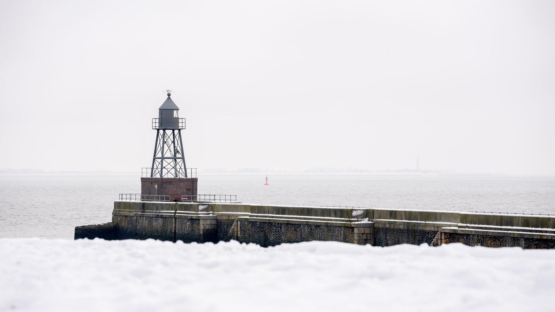 Ein Querfeuer steht bei winterlichem Wetter auf einer Mole am Jadebusen. | picture alliance/dpa | Hauke-Christian Dittrich