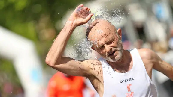 Teilnehmer des Hamburger Marathons überschüttet sich mit Wasser
