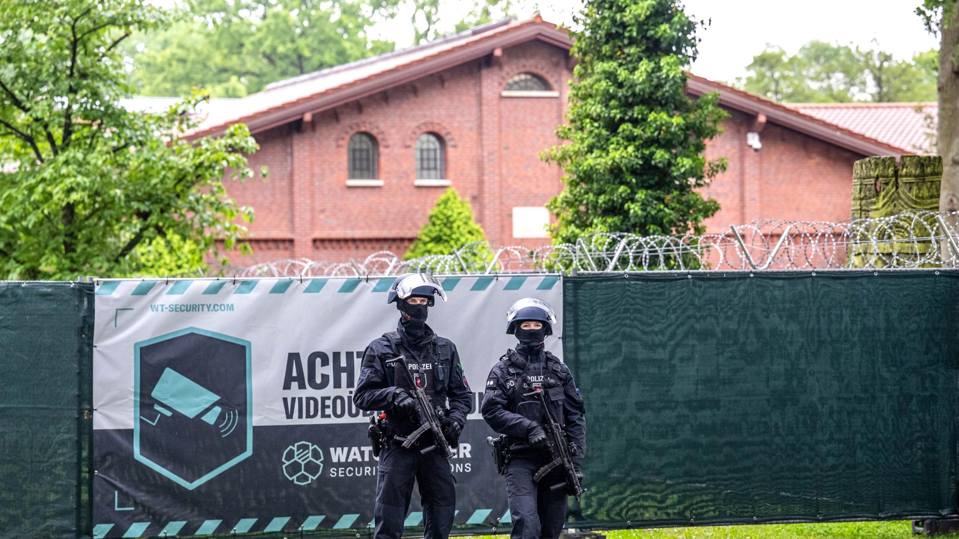Einsatzkräfte sichern eine umfunktionierte Reithalle und das umliegende Gelände.  | picture alliance / dpa, Sina Schuldt