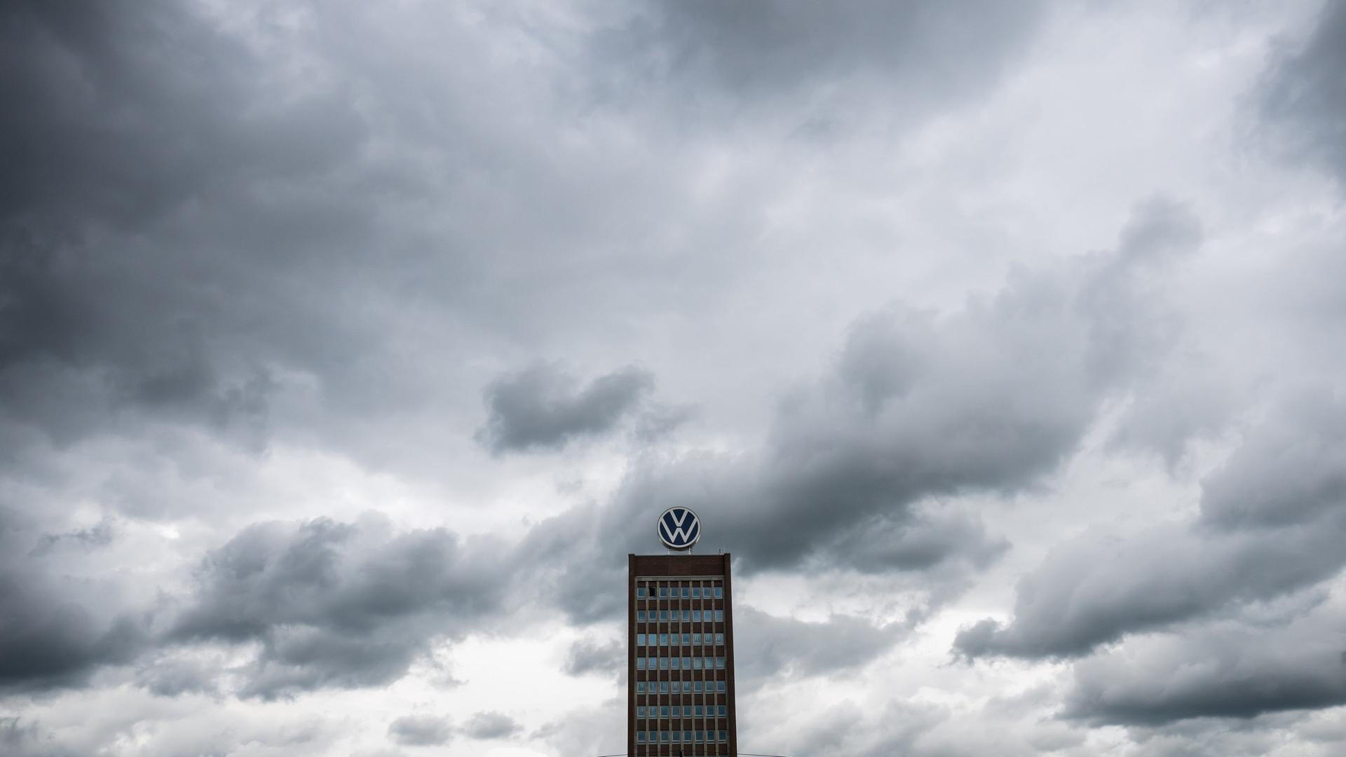 Dunkle Wolken ziehen über das Markenhochhaus auf dem Gelände vom VW Werk Wolfsburg hinweg. | picture alliance/dpa, Julian Stratenschulte