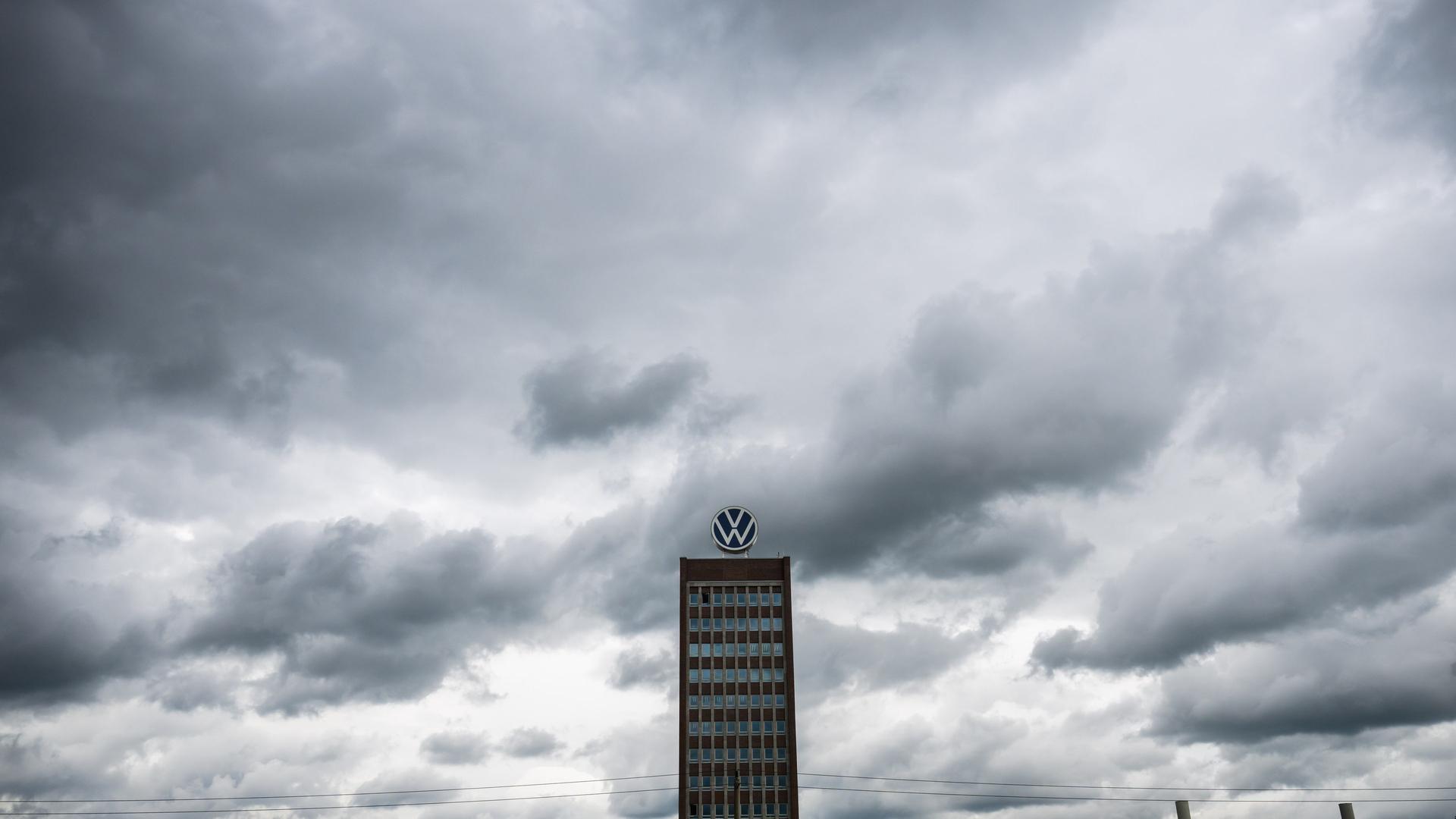 Dunkle Wolken ziehen über das Markenhochhaus auf dem Gelände vom VW Werk Wolfsburg hinweg. | picture alliance/dpa, Julian Stratenschulte
