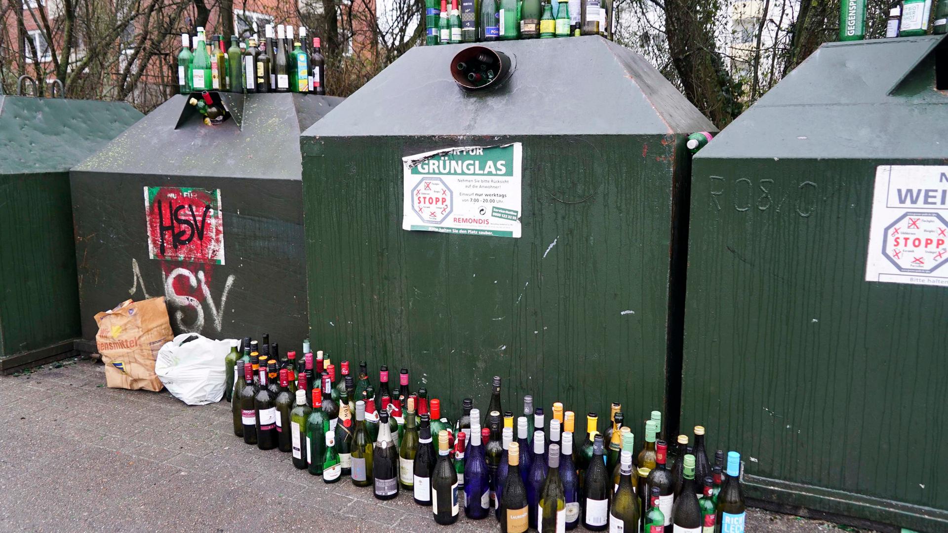 Leere Glasflaschen die vor einem und auf einem Altglascontainer stehen. | picture alliance /ABBfoto
