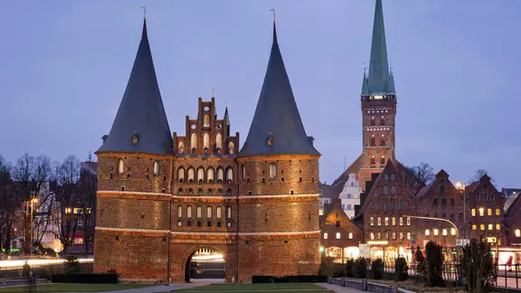 Das Holstentor in Lübeck und die St. Petri Kirche am Abend | imago/imagebroker Das Holstentor in Lübeck und die St. Petri Kirche am Abend