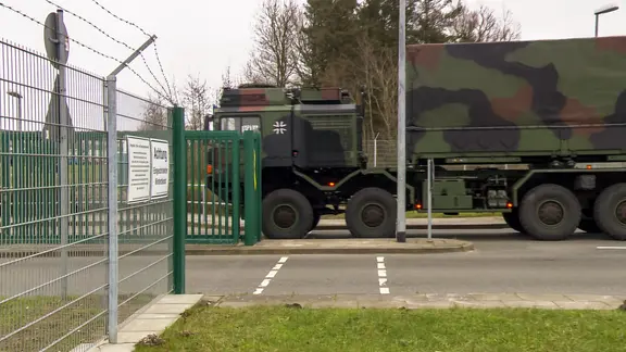 Ein Militärfahrzeug fährt duch das Tor eines Militärstützpunktes.