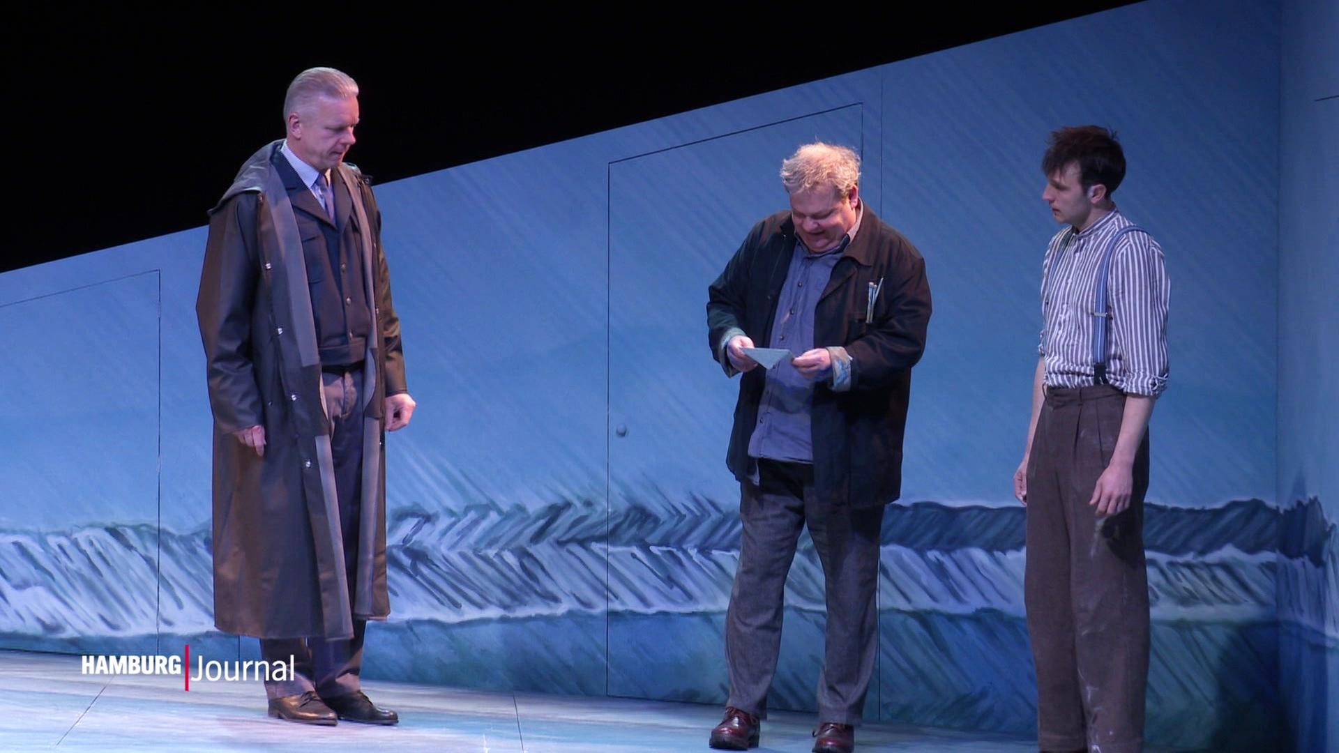 Drei Schauspieler stehen auf einer Bühne. | Screenshot