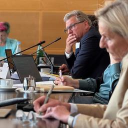 Bernd Buchholz (FDP) sitzt mit anderen Kolleginnen und Kollegen in einem großen Konferenzraum im Kieler Landeshaus.