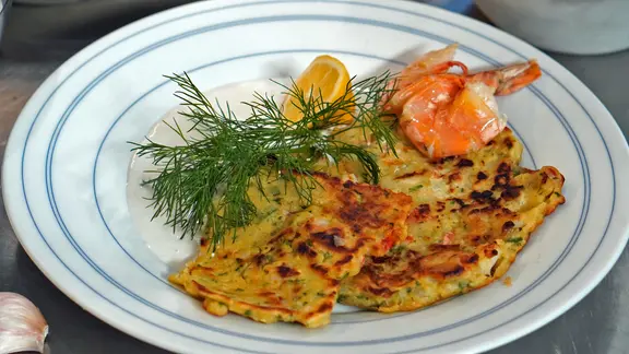 Zwei Tortillas mit Garnele, Zitrone und Kräutern auf einem Teller serviert.