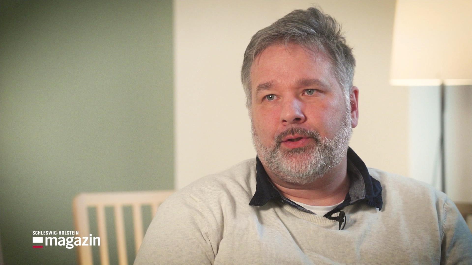 Ein bärtiger Mann um die 50 Jahre. | Screenshot