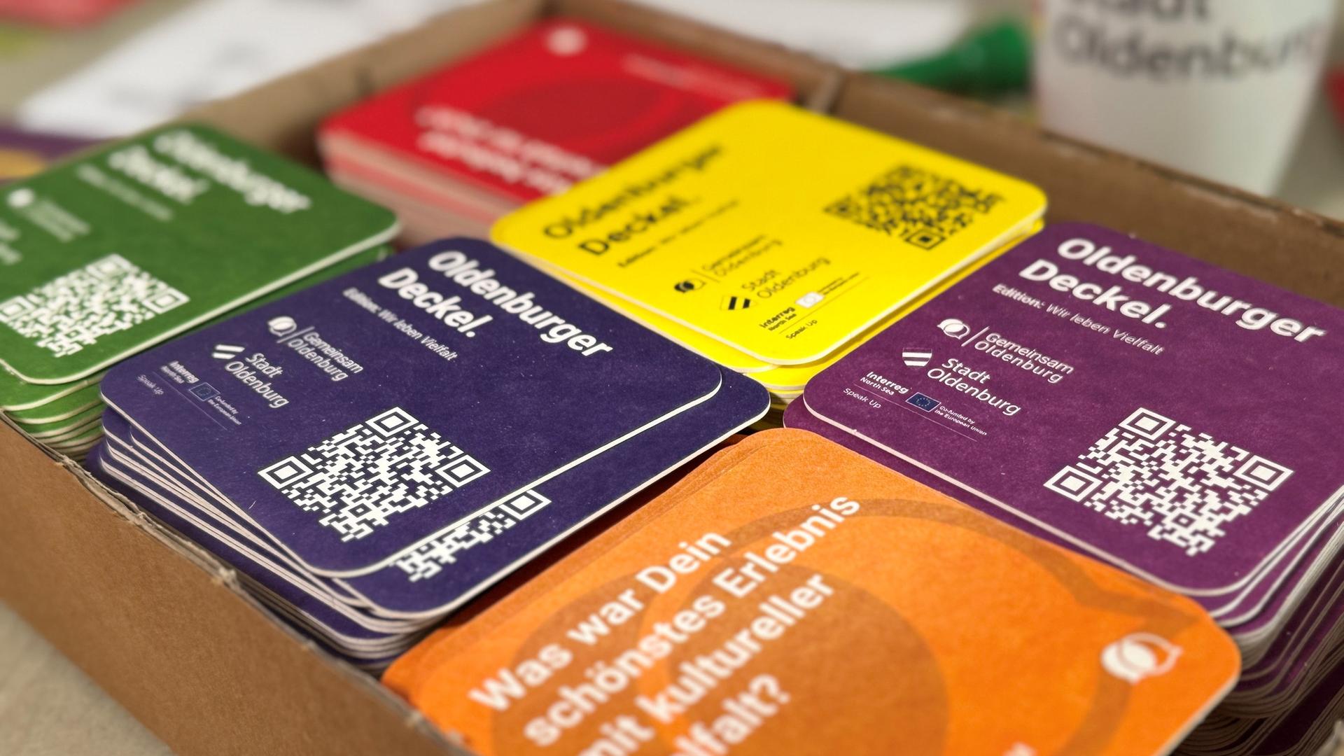 Interaktive bunte Bierdeckel liegen im Pappkarton. | NDR
