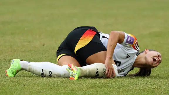 Nationalspielerin Lena Oberdorf liegt auf dem Rasen und hält sich das Knie. | IMAGO / Jan Huebner Nationalspielerin Lena Oberdorf liegt auf dem Rasen und hält sich das Knie.