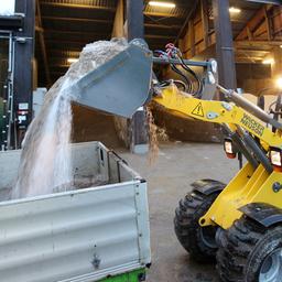 Ein Bagger der Hamburger Stadtreinigung belädt ein Fahrzeug mit Streumittel.