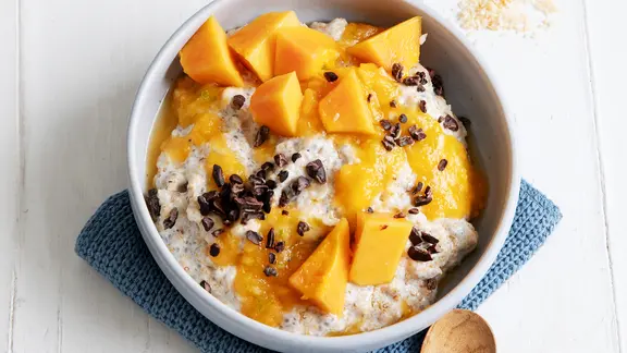 Ein Haferbrei, darauf Papayastücke und Kakao-Nibs. | ZS-Verlag, Claudia Timmann Ein Haferbrei, darauf Papayastücke und Kakao-Nibs.