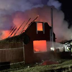 Feuerwehrleute löschen ein brennendes Wohnhaus