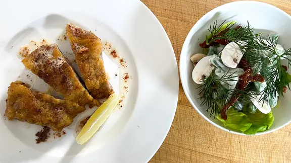 Cordon bleu mit grünen Bohnen in Zitronensahne auf einem Teller angerichtet