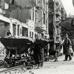 Sogenannte Trümmerfrauen entsorgen in den Jahren nach dem Zweiten Weltkrieg Schutt mit Loren.