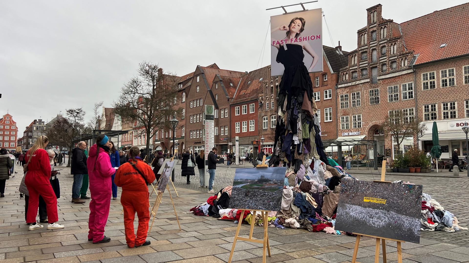 Aktivisten sammeln vor einer Statue aus alten Kleidern Unterschriften. | NDR, Marlene Kukral