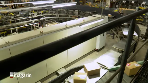In einem Paketzentrum werden Pakete von einer Maschine sortiert