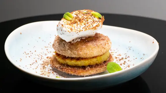 Süßer Burger mit Ananas, Baiser und Minzeöl auf einem Teller serviert