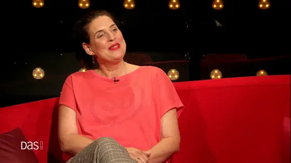 Elena Uhlig auf dem roten Sofa.